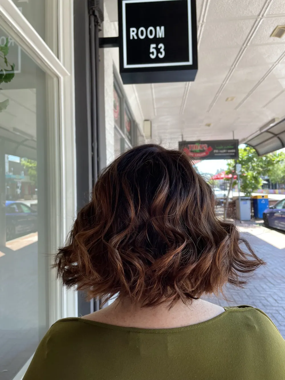 Curly chocolate bob outside the salon under the Room 53 sign