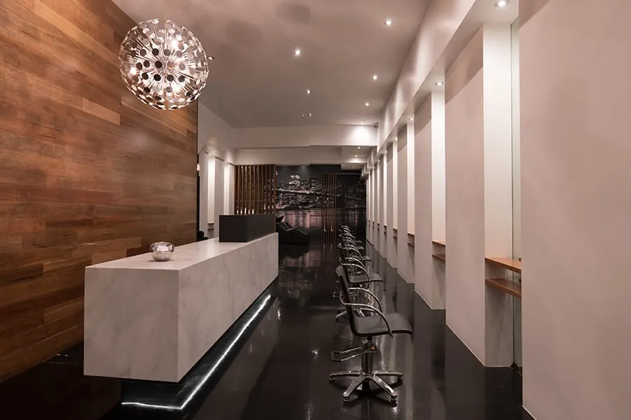 White stone reception desk and the long gloss-black styling floor