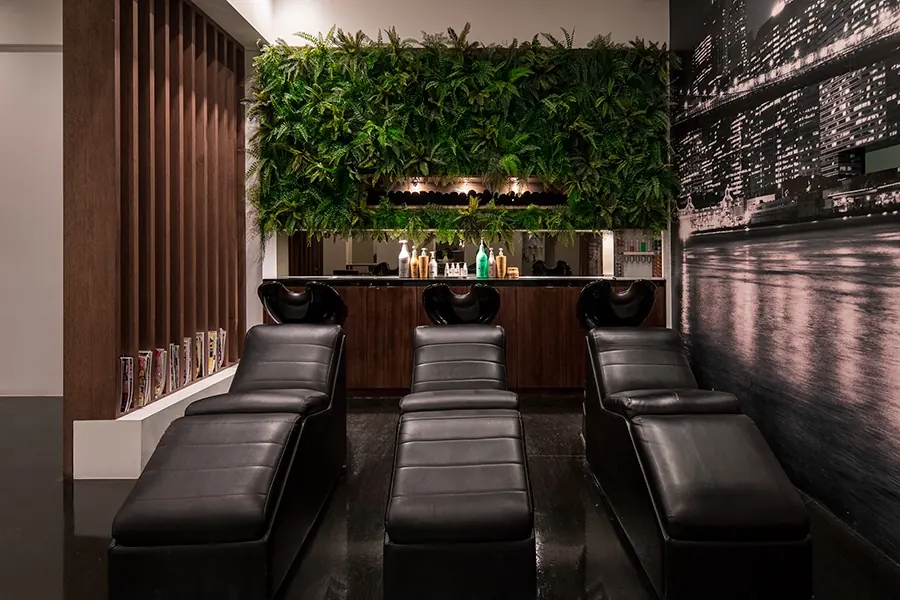 Black leather wash chairs under Room 53's living green wall